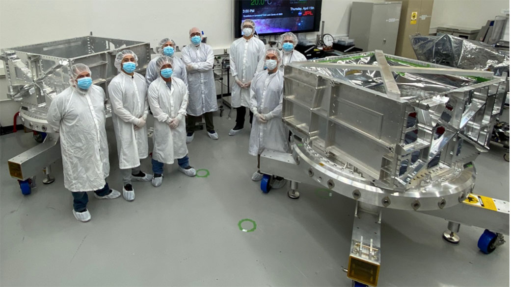Engineers and technicians in a clean room at NASA’s Jet Propulsion Laboratory display the thick-walled aluminum vault they helped build for the Europa Clipper spacecraft.