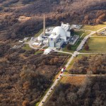 Aerial view of the Neil A. Armstrong Test Facility, with a truck carrying Orion Spacecraft visible in the foreground approaching the facility.