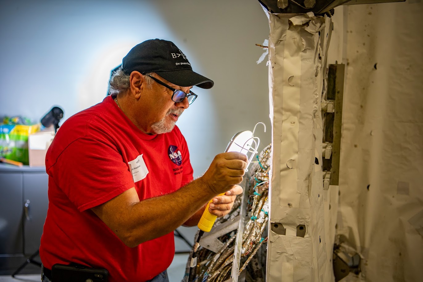 Retired NASA engineer Mike Haddad inspects the Astro cruciform during refurbishment efforts at the U.S. Space & Rocket Center.