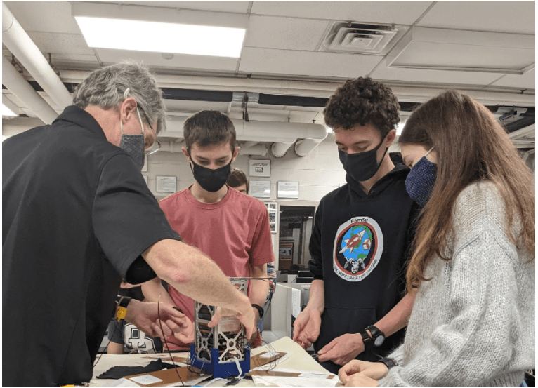 Robertsville Middle School students and their mentor work on their CubeSat named RamSat. 