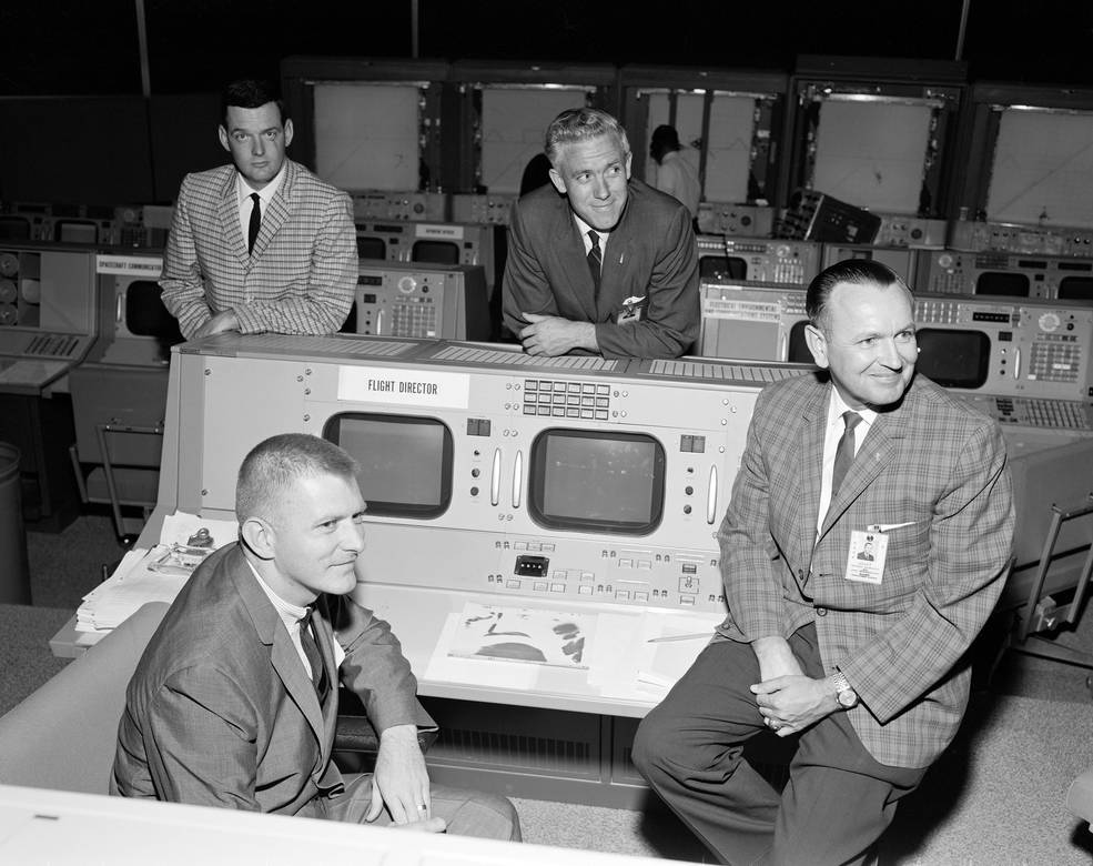 4 flight directors are seen in the mission operations control room in 1965.