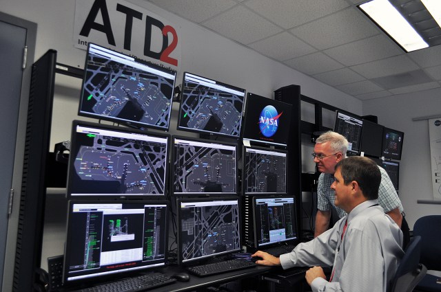 Researchers Al Capps (seated) and Paul Borchers demonstrate Airspace Technology Demonstration 2 (ATD-2) tools that air traffic managers began testing in 2017.