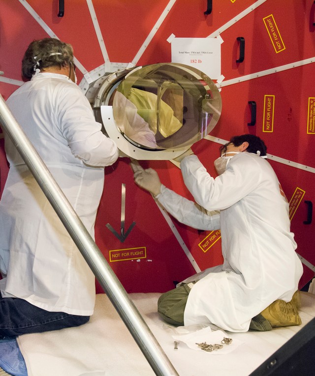 Technicians installing the tertiary mirror onto the SOFIA telescope.