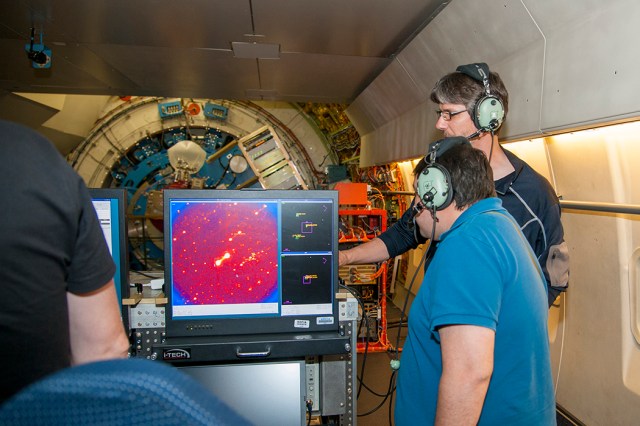 Astronomers smile while looking at data from SOFIA?s telescope.