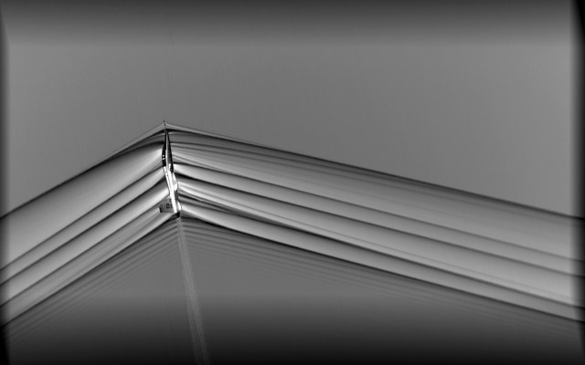 Schlieren image of a T-38 aircraft creating shock waves during supersonic flight.