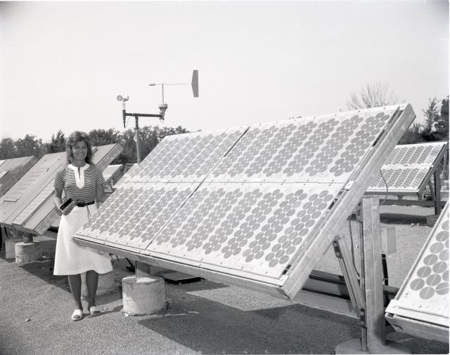 1978 black and white show of Dr. Patricia O'Donnel standing next to a large bank of solar panels.