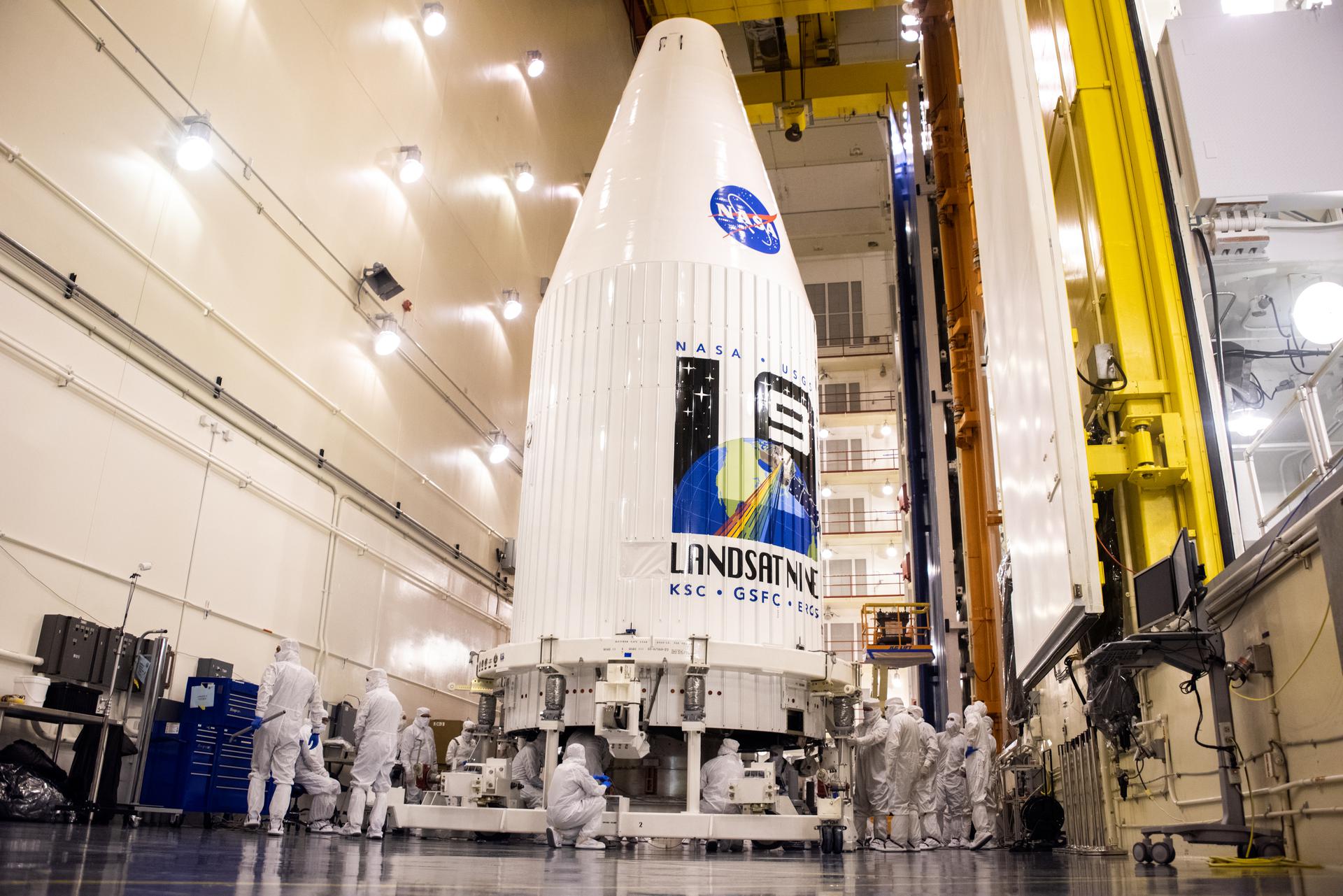 Inside the Integrated Processing Facility at Vandenberg Space Force Base in California, both United Launch Alliance (ULA) payload fairings are secured around the Landsat 9 spacecraft on Aug. 16, 2021. 
