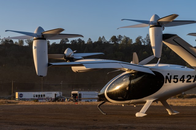 Joby's prototype aircraft in the front of the image. Behind the aircraft in the background is the RVLT Mobile Acoustic Facility.