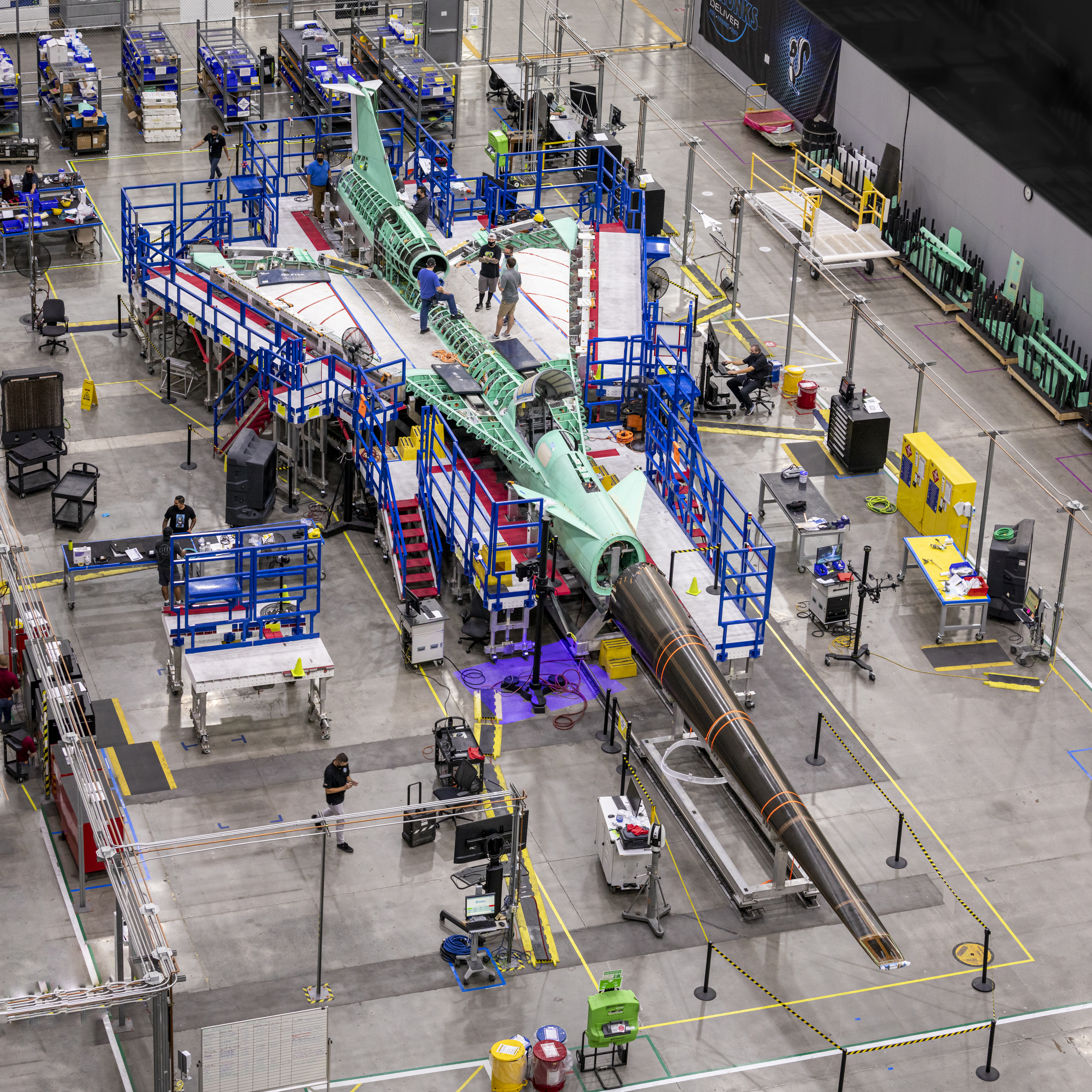 The X-59 Quiet SuperSonic Technology aircraft being assembled at the Lockheed Martin Skunk Works facility in Palmdale, California. In this image the nose of the X-59 is being placed on at the front of the aircraft.
