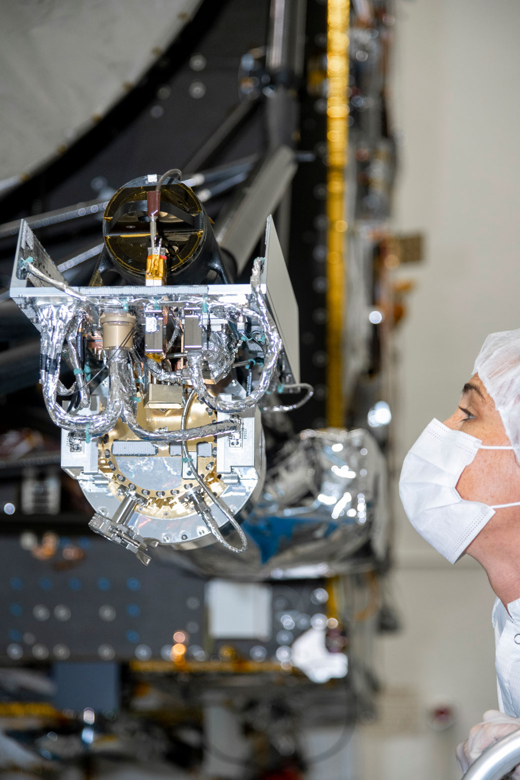 At NASA’s Jet Propulsion Laboratory, an engineer inspects the gamma ray and neutron spectrometer as it is integrated into the agency’s Psyche spacecraft.
