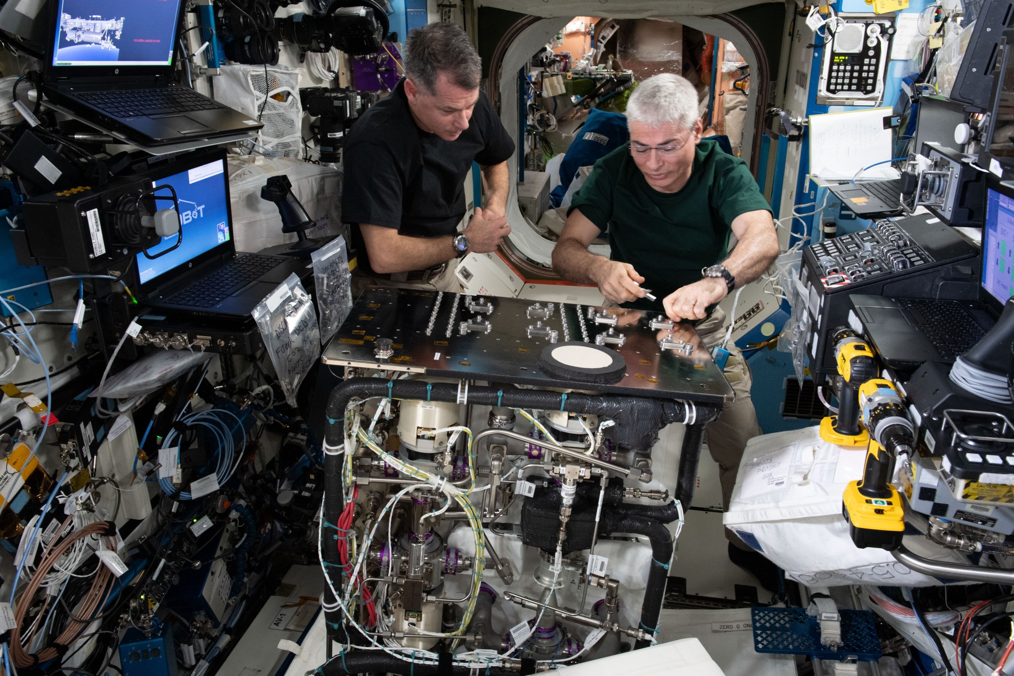 International Space Station crew members Shane Kimbrough, left, and Mark Vande Hei work to install the 4-Bed Carbon Dioxide Scrubber.