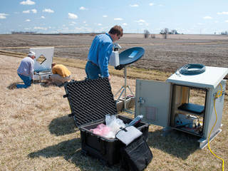 Technician installing instrumentation in a field.