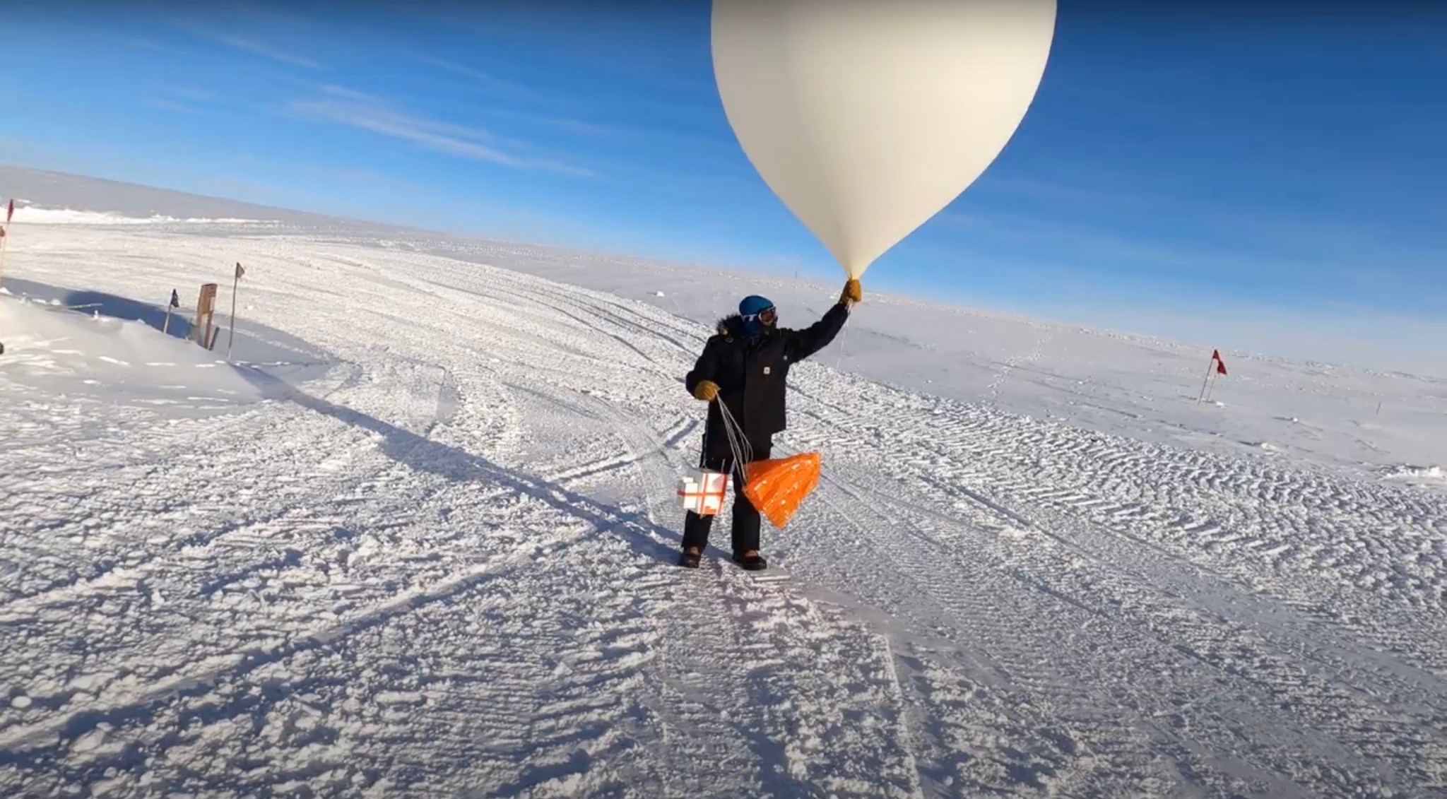 A scientist launches a weather balloon carrying an ozonesonde from South Pole Station in March of 2021.