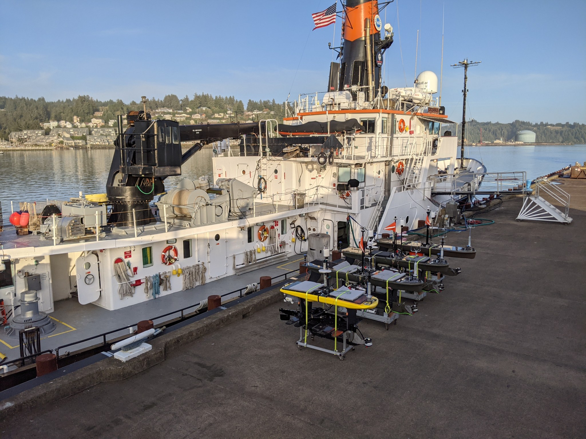 Several autonomous marine robots, including these Wave Gliders from Scripps Institute of Oceanography and the Woods Hole Oceanographic Institute, will deploy from R/V Oceanus ship.