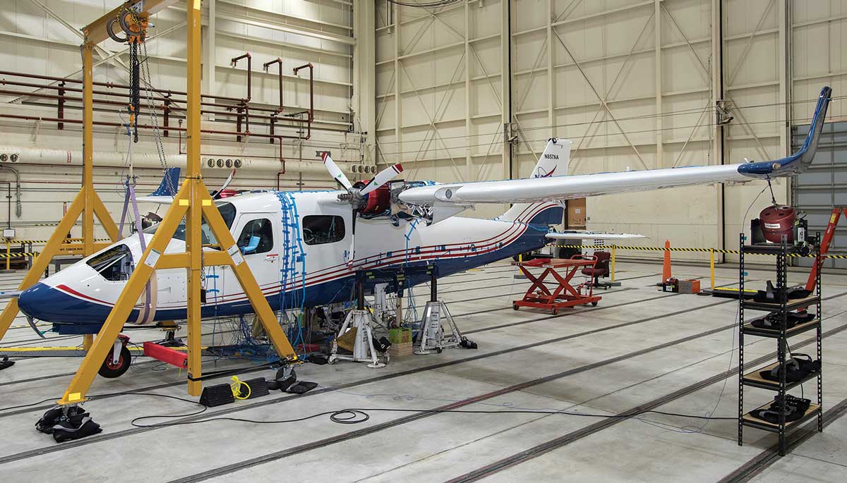 Body of an aircraft inside of a hangar.