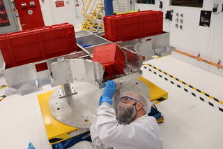 An engineer secures 3D-printed plastic parts using a special lift-table to access the insides of the NASAs Volatiles Investigating Polar Exploration Rover, orâ€¯VIPER practice-build.