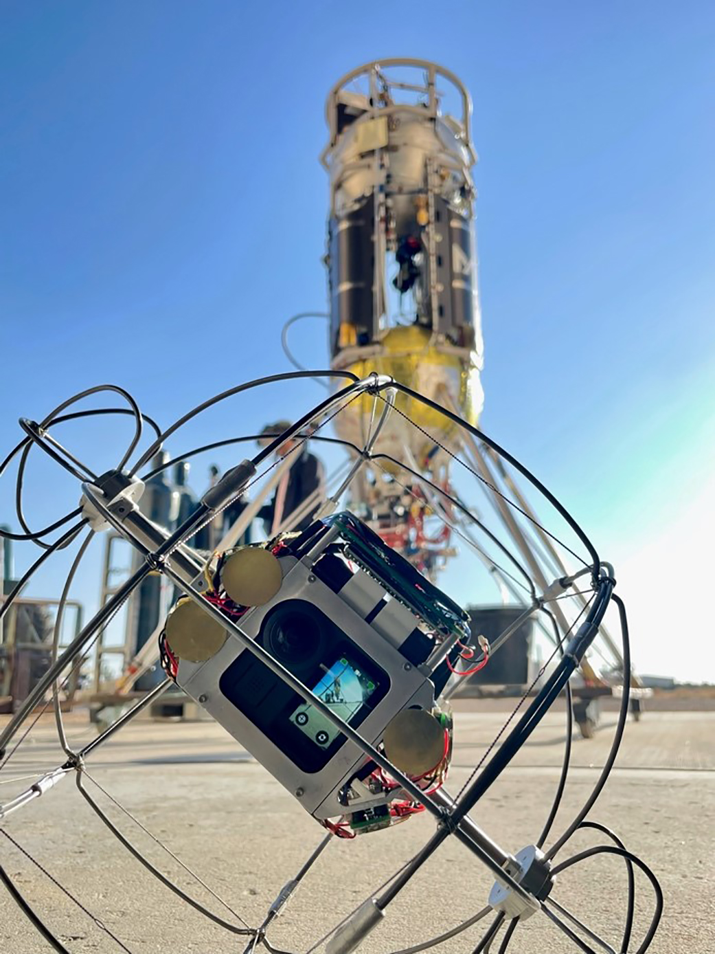 Camera in round metal cage in the desert.