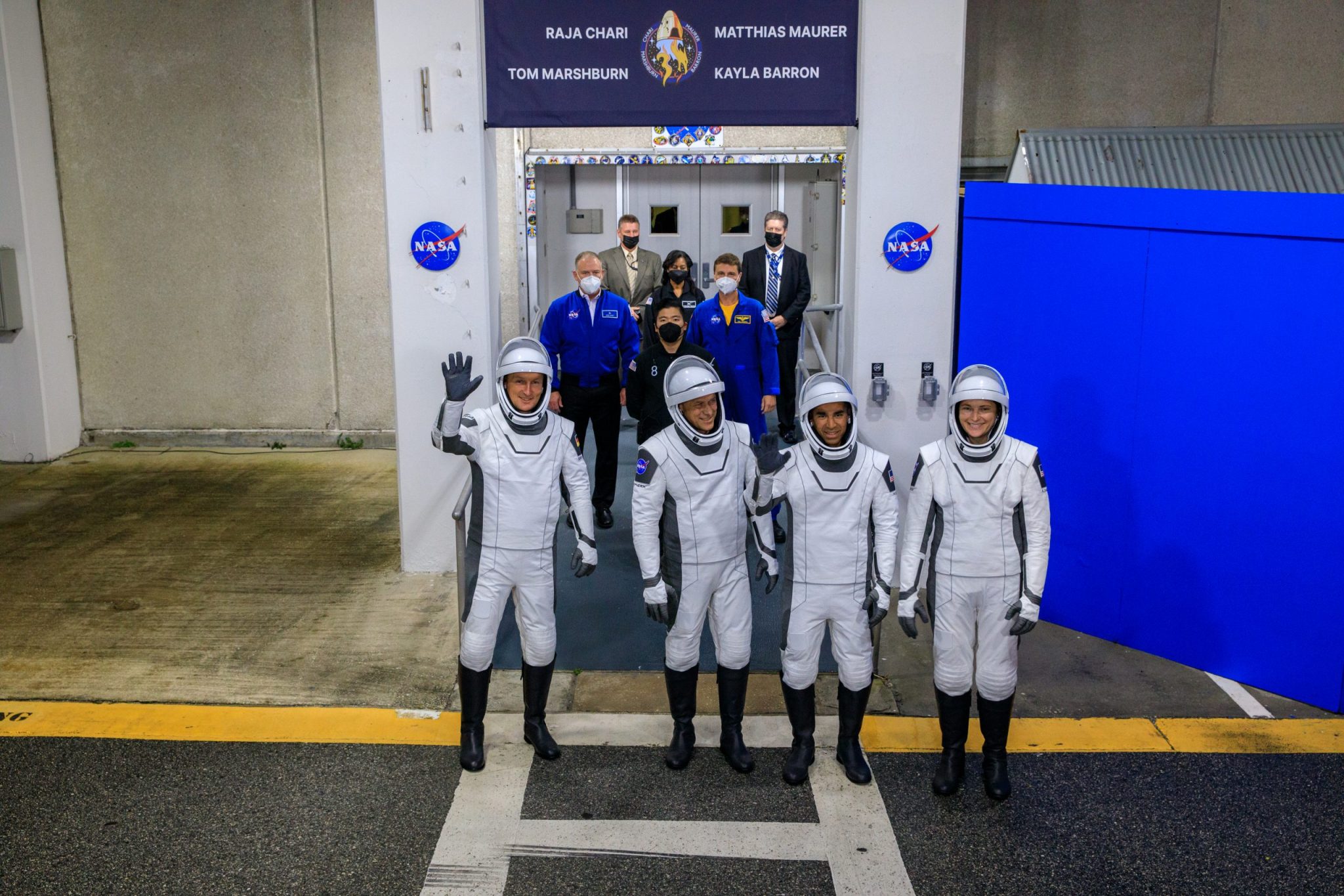 The SpaceX Crew-3 astronauts wave to family and friends after walking out through the double doors below the Neil A. Armstrong Building’s Astronaut Crew Quarters at NASA’s Kennedy Space Center in Florida on launch day, Nov. 10, 2021.