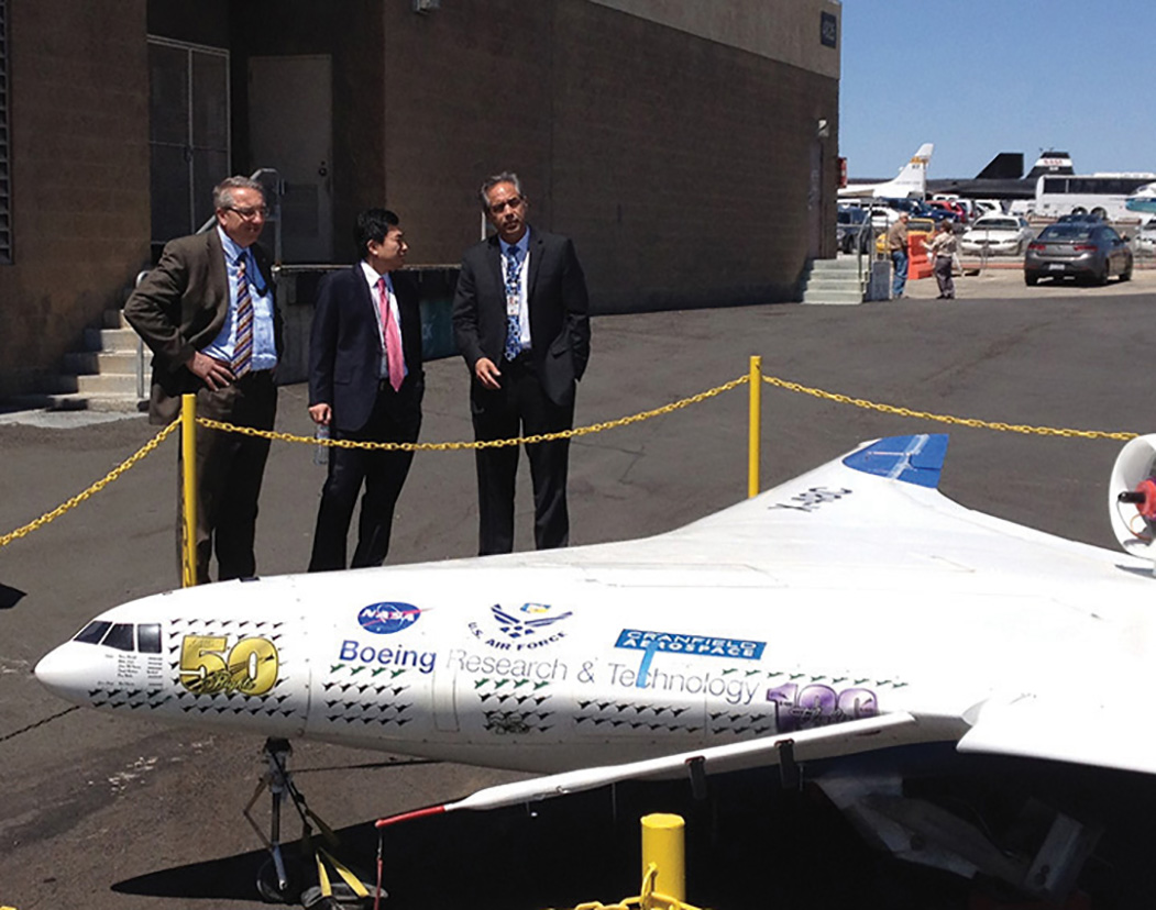 Armstrong Director with guests, looking at an aircraft outside a hangar.