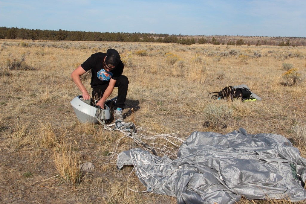 SpaceWorks Enterprises’ Zack Reinhardt assesses the company’s RED-4U capsule after a successful landing.