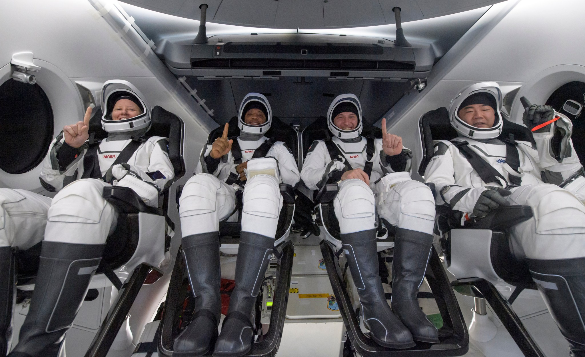NASA astronauts Shannon Walker, Victor Glover, Mike Hopkins, and Japan Aerospace Exploration Agency (JAXA) astronaut Soichi Noguchi seated in a SpaceX GO Navigator recovery ship.