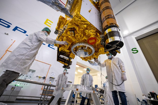DART team members carefully lower the DART spacecraft onto a low dolly