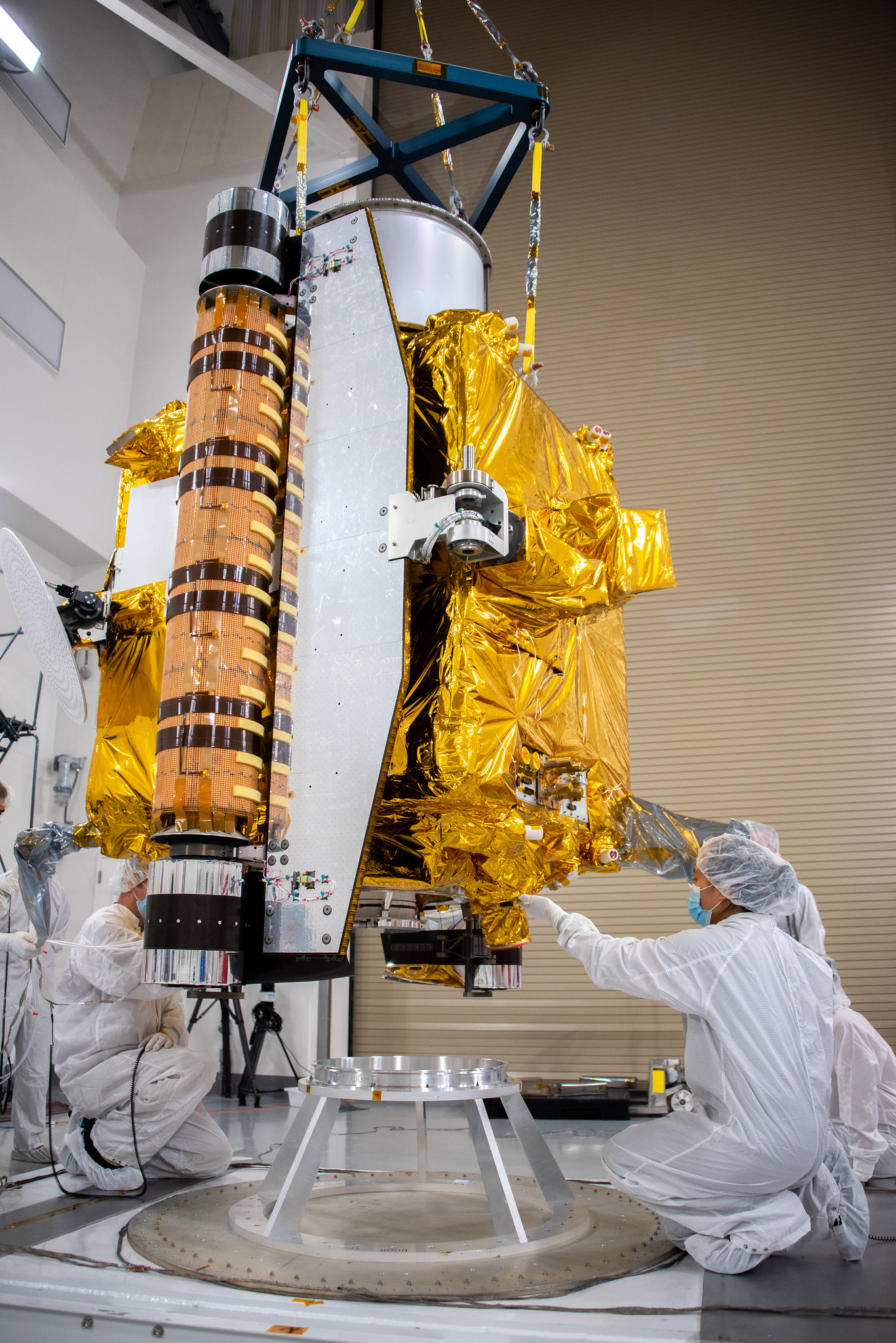 Technicians lower NASA's Double Asteroid Redirection Test (DART) spacecraft onto a work stand inside the Astrotech Space Operations Facility at Vandenberg Space Force Base in California on Oct. 4, 2021. 