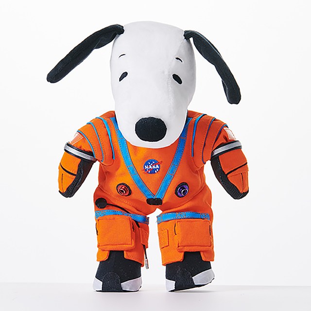 A stuffed toy of Snoopy wearing an orange Artemis spacesuit