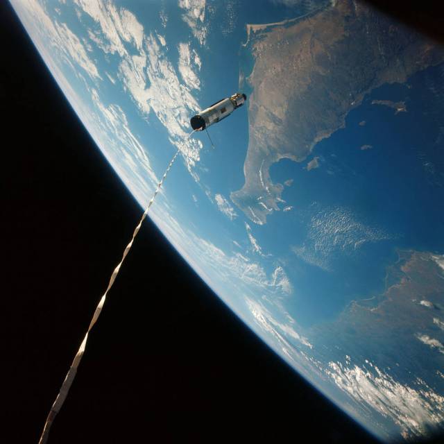 The Agena XII target vehicle, attached to Gemini XII by a 100-foot tether. The Earth can be seen in the background