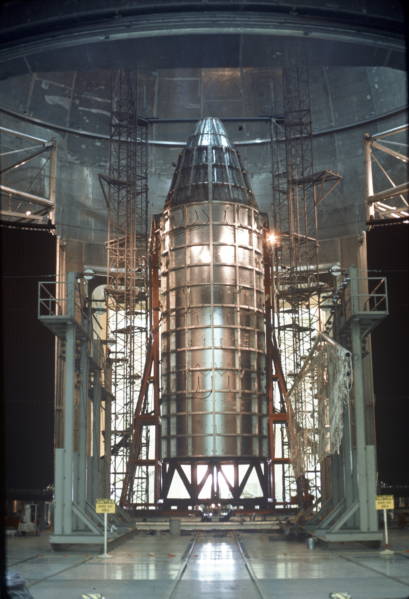 Spacecraft in vacuum chamber surrounded by scaffolding.
