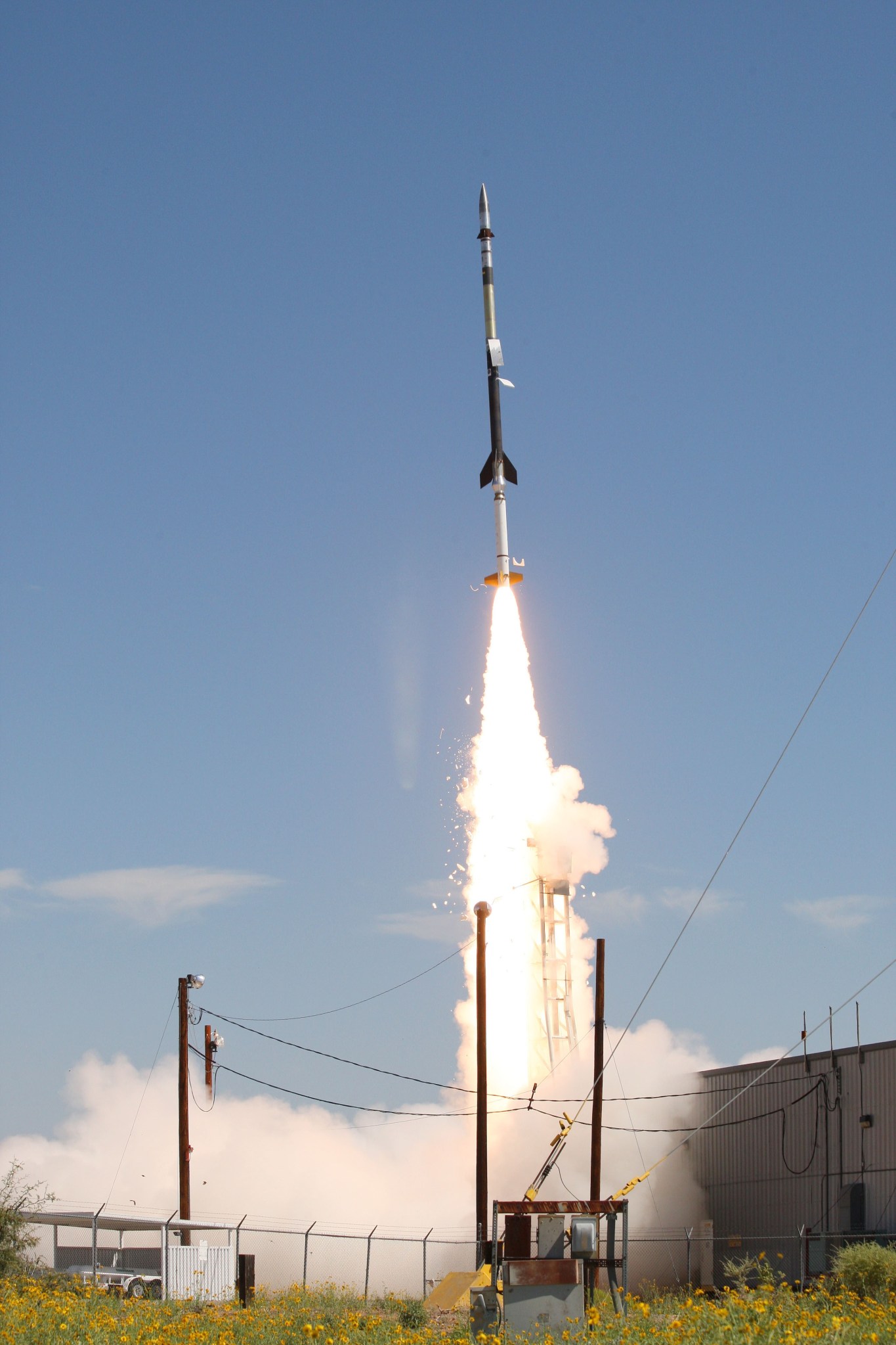 HERSCHEL sounding rocket launch; slender rocket taking flight against a blue-sky background