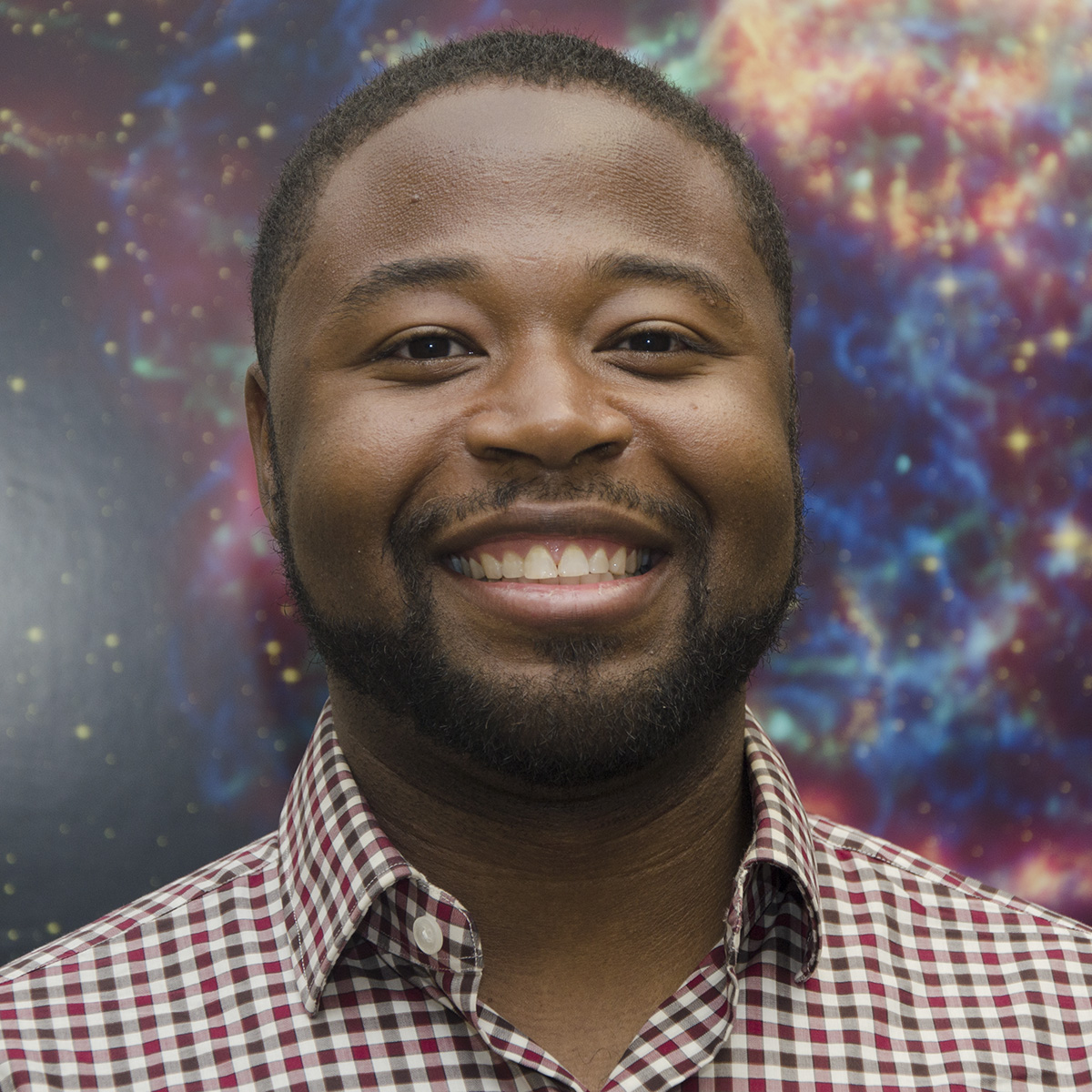 Portrait photo of Greg Mosby, Jr. with blue and purple starry background.
