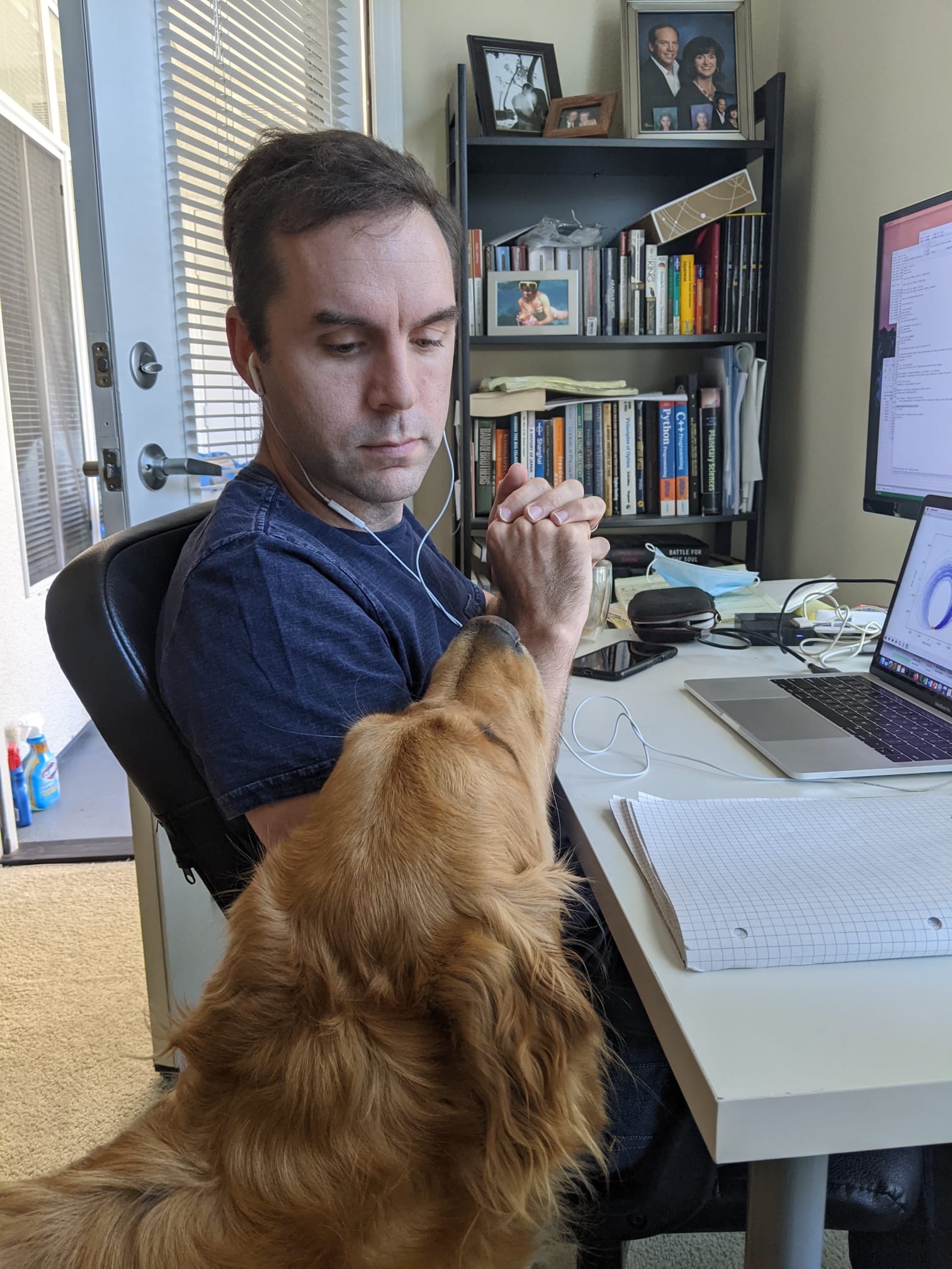 A recent image of Thayne trying to work remotely with his dog begging for food/attention