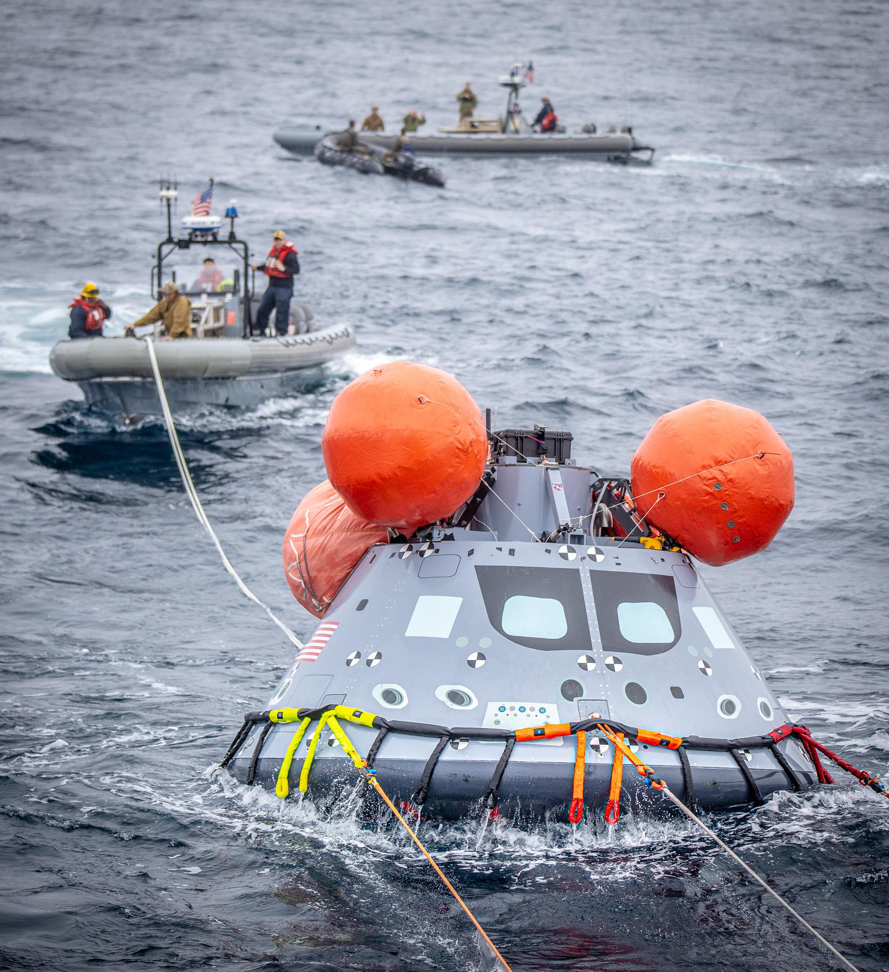 Navy divers from Explosive Ordnance Disposal (EOD) Expeditionary Support Unit 1, practice recovering a mock Orion capsule during Day 2 of Underway Recovery Test 9.