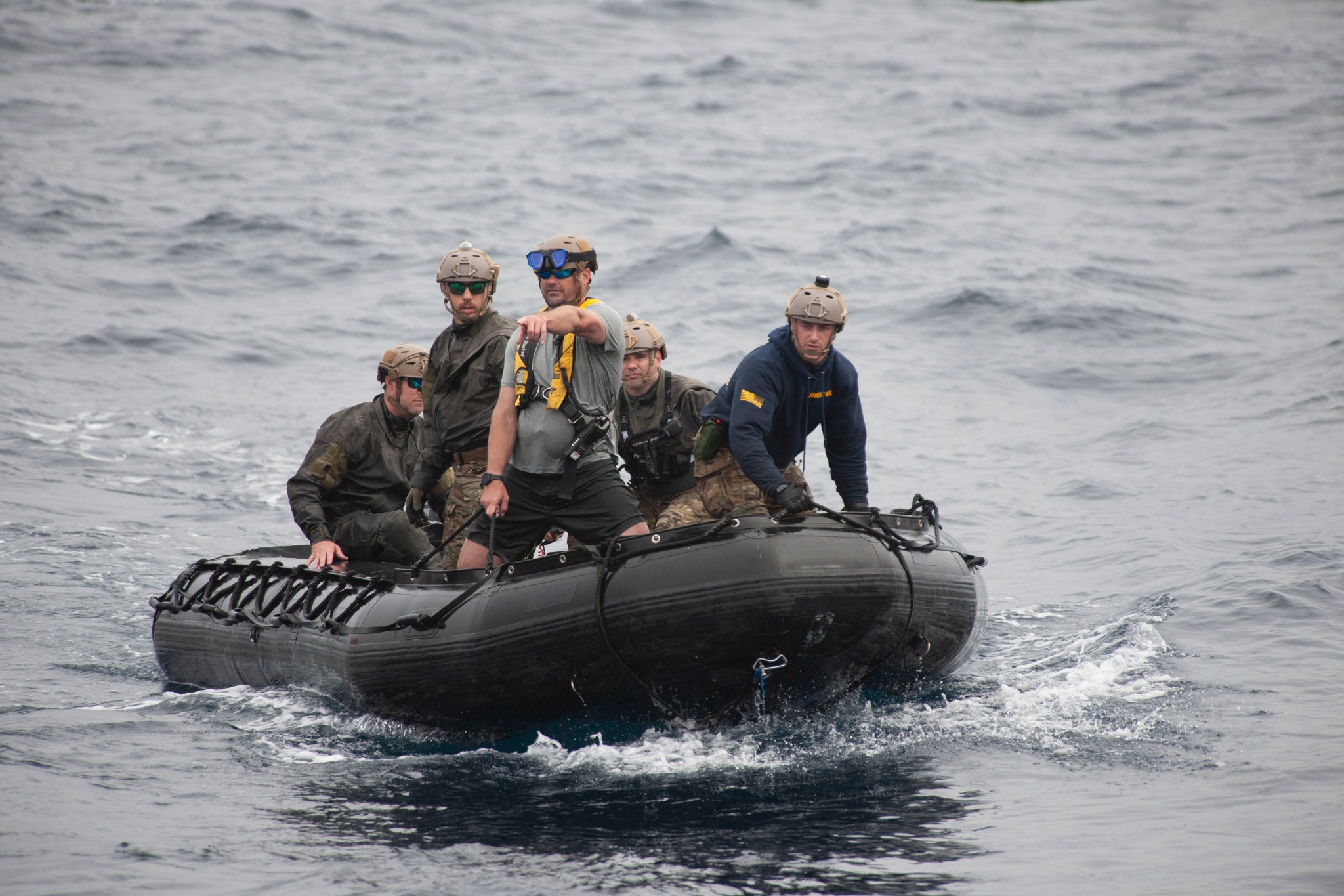 Open Water Lead Tim Goddard points the way to the smoke the helicopter dropped in the water, indicating the location of the mock Orion capsule during Underway Recovery Test 9 (URT-9).