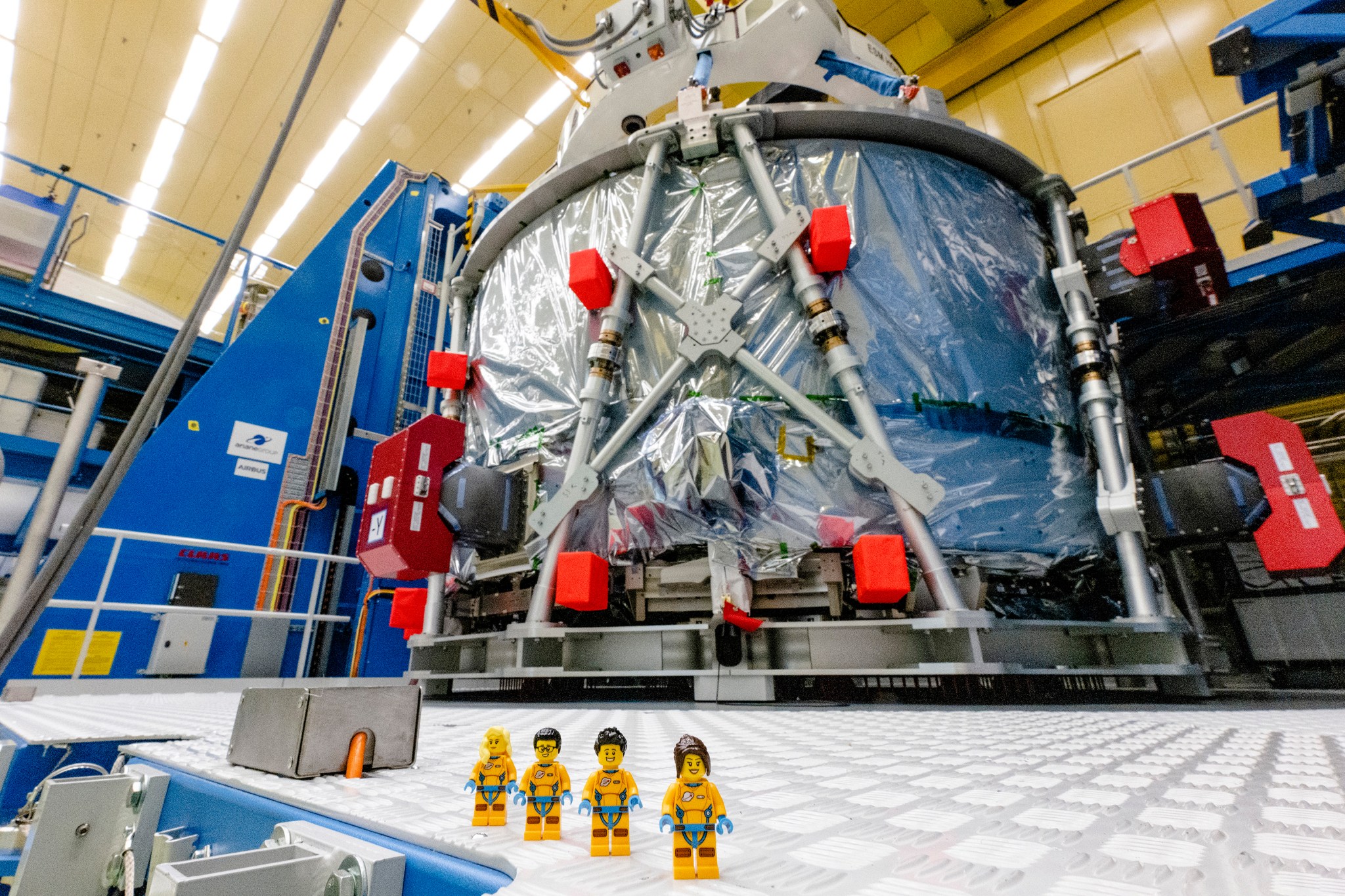 Representative LEGO minifigures in front of European Service Module that will power the Orion spacecraft on Artemis II. Four LEGO minifigures will fly on Artemis I as part of the official flight kit.