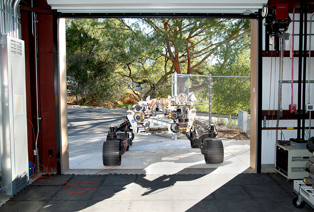OPTIMISM faces a doorway of JPL’s Mars Yard garage 