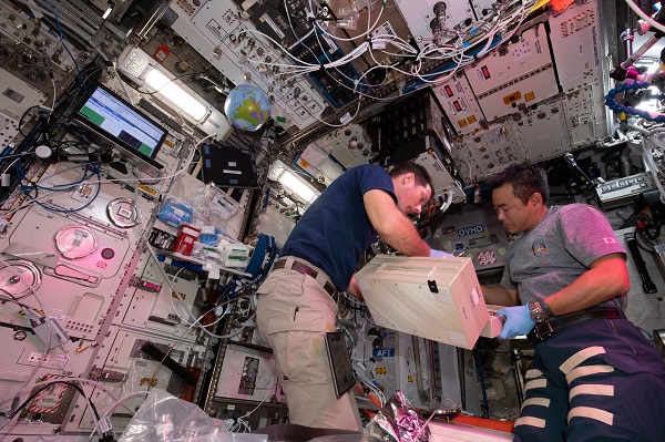image of two astronauts working with an experiment