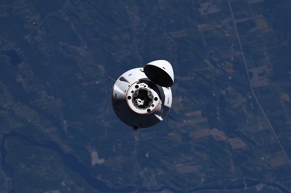image of a capsule with earth in backdrop