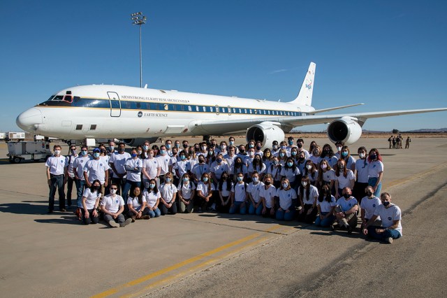 NASA Student Airborne Research Program students, mentors and faculty pose in front of NASA's DC-8 on December 7, 2021 at Armstrong Flight Research Center Building 703.