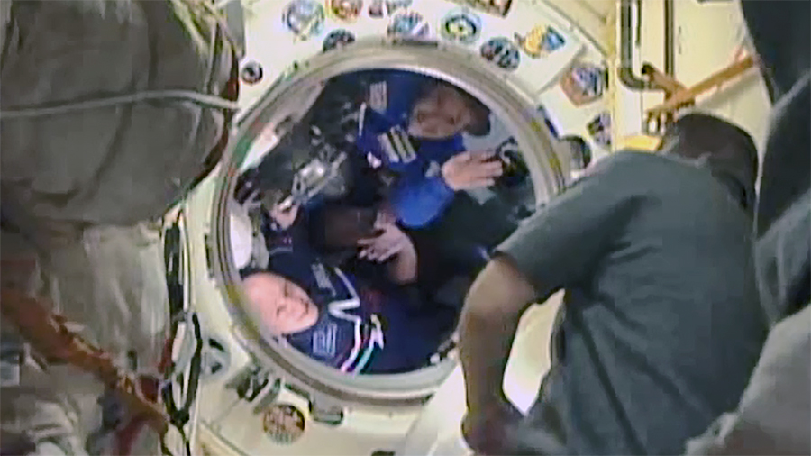 Cosmonaut Alexander Misurkin and spaceflight participants Yusaku Maezawa and Yozo Hirano wave goodbye before closing the Soyuz vehicle's hatch. Credit: NASA TV