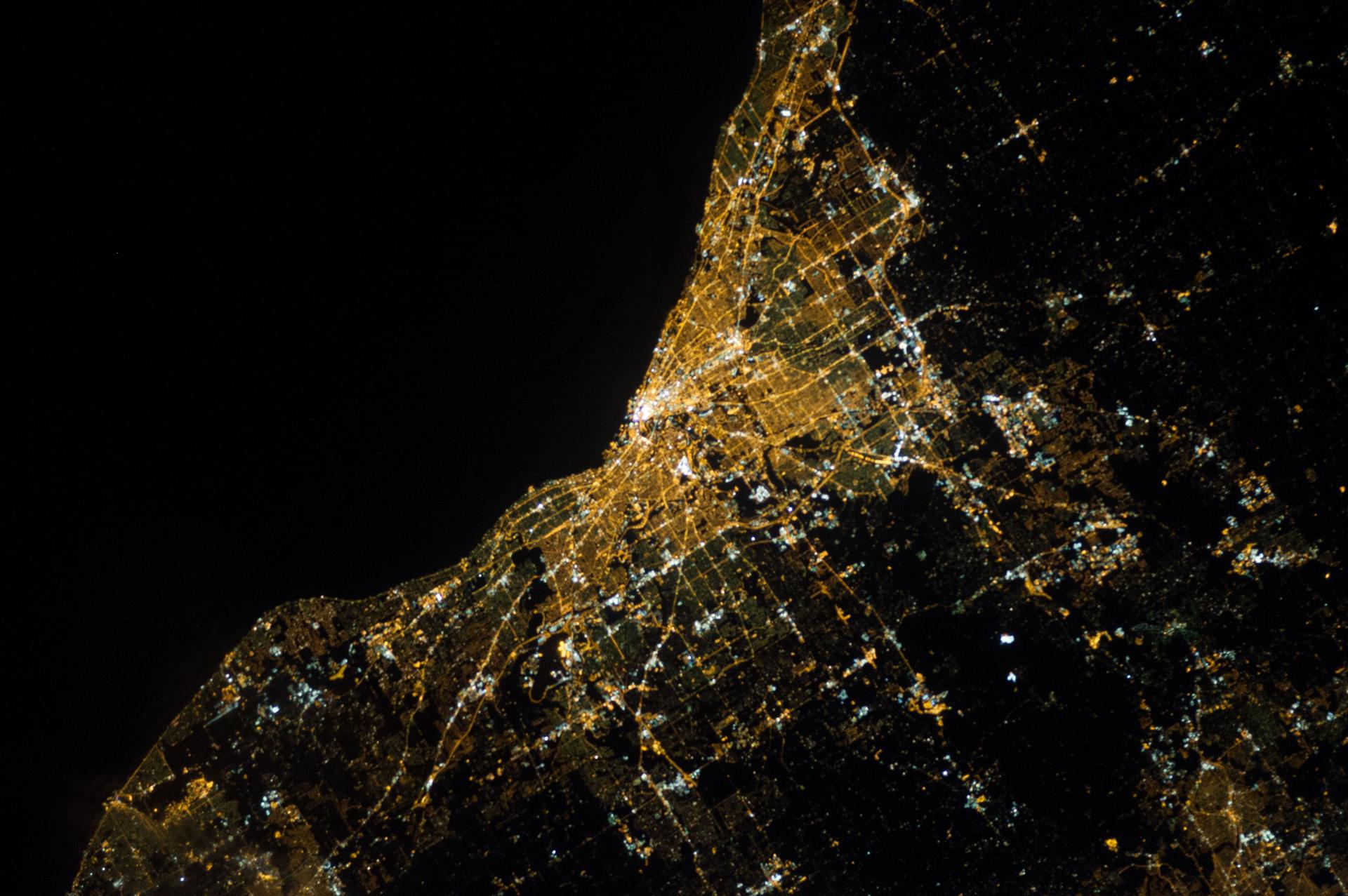 Dark background and lights in the city of Cleveland as seen from space.