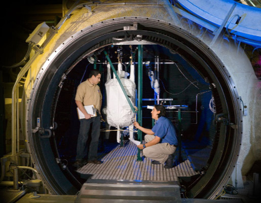 Two men working within the 15-foot chamber at Johnson Space Center