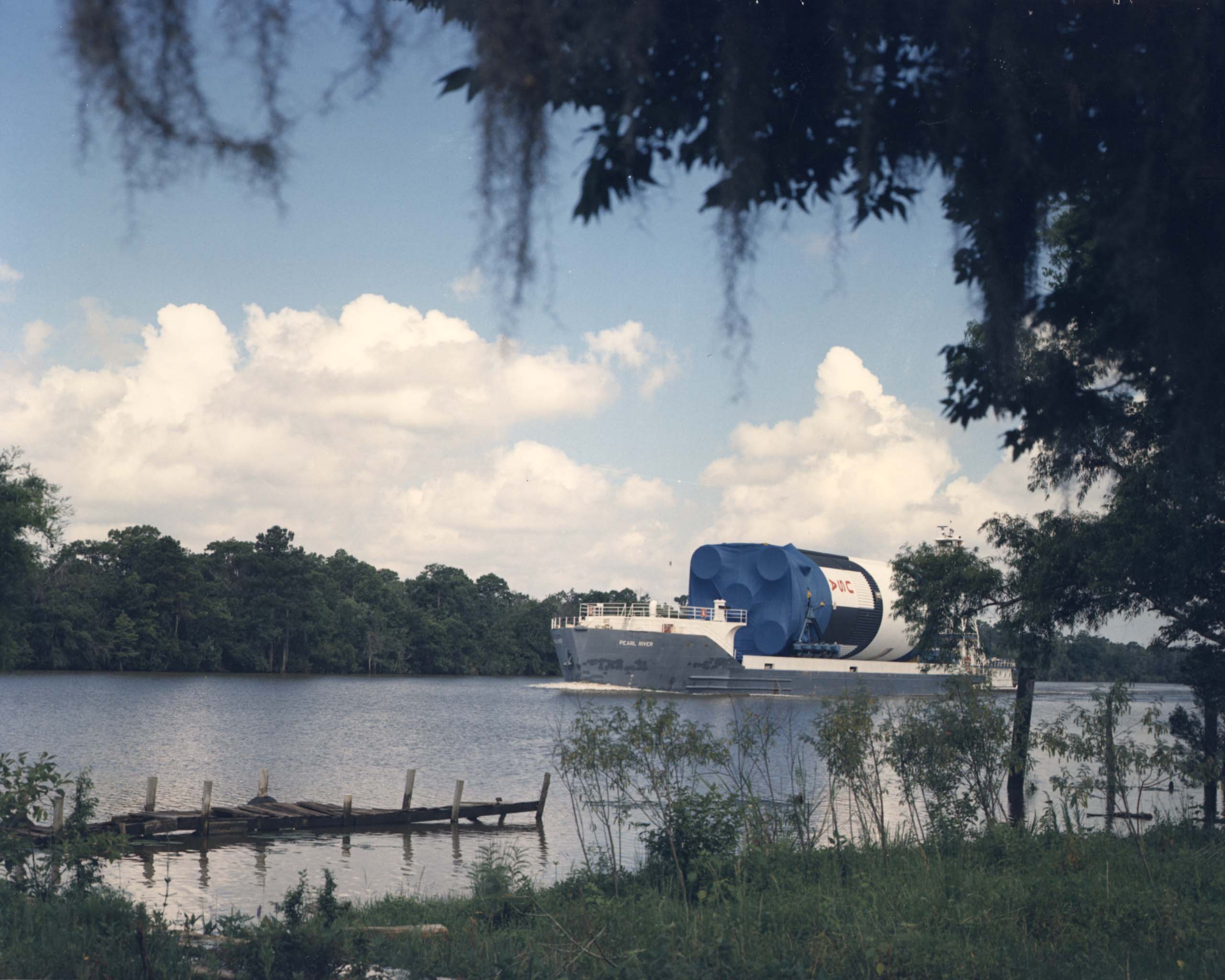 The first stage of the Saturn V rocket is transported by barge down the East Pearl River.