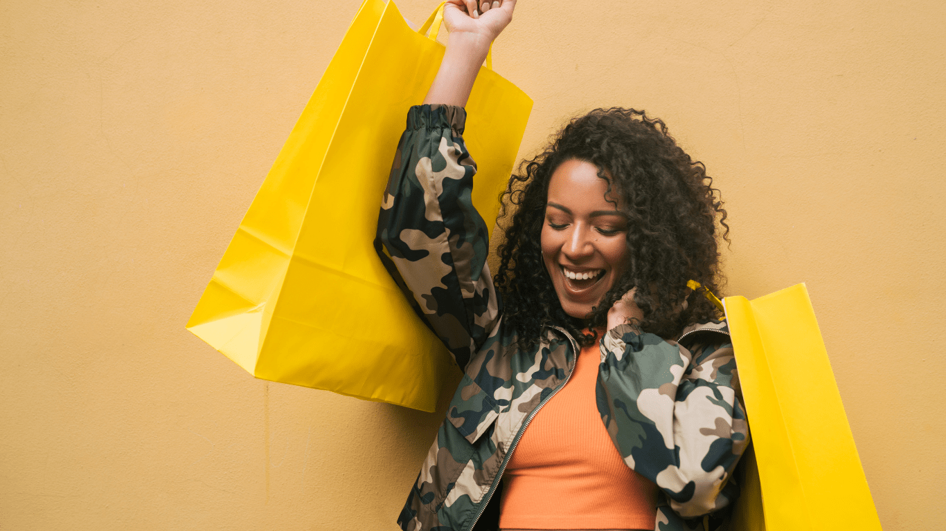 smiling woman holding yellow shopping bags