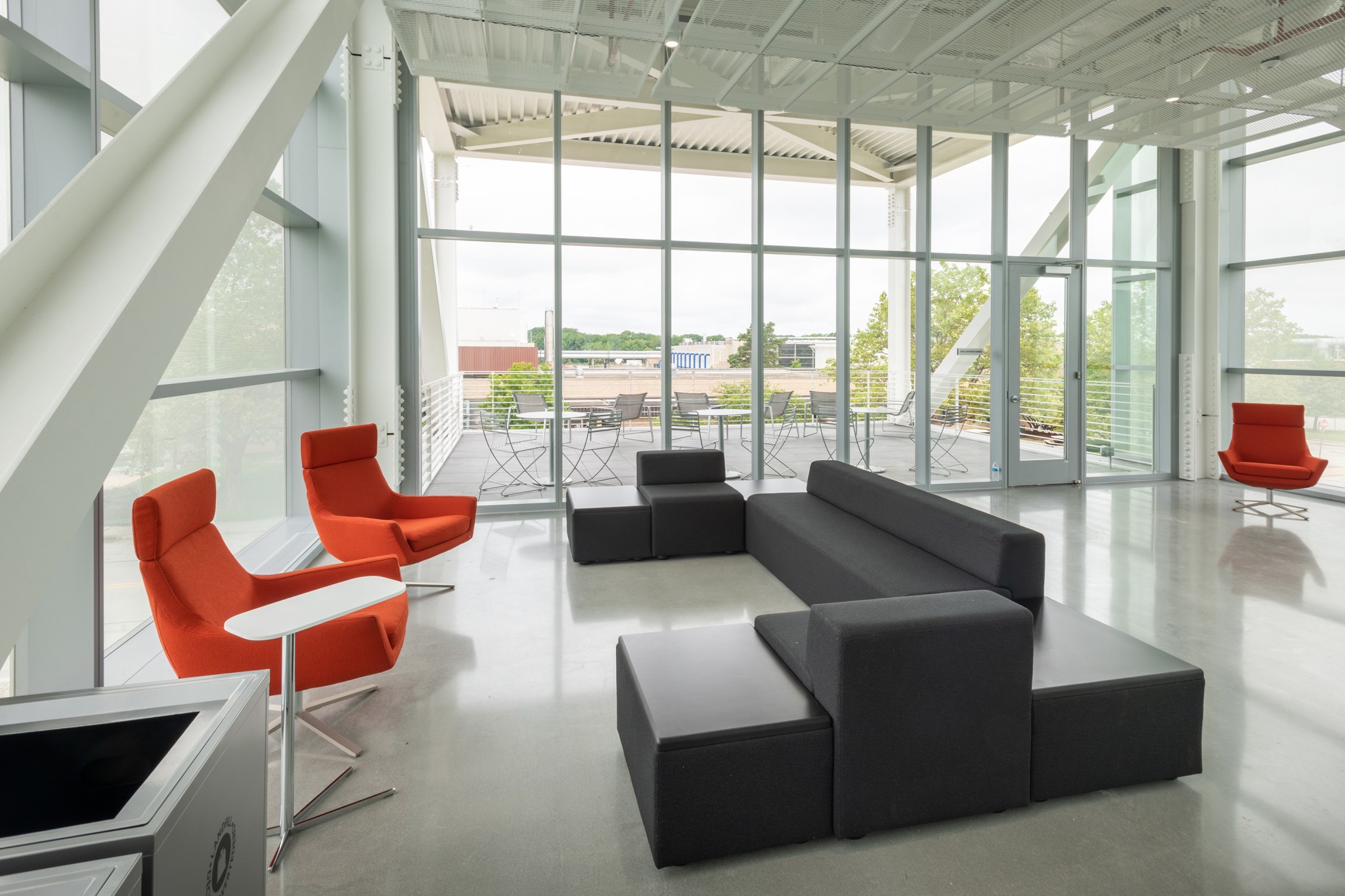 qConversation area with a large window in the background and comfortable chairs and a sofa in the foreground.