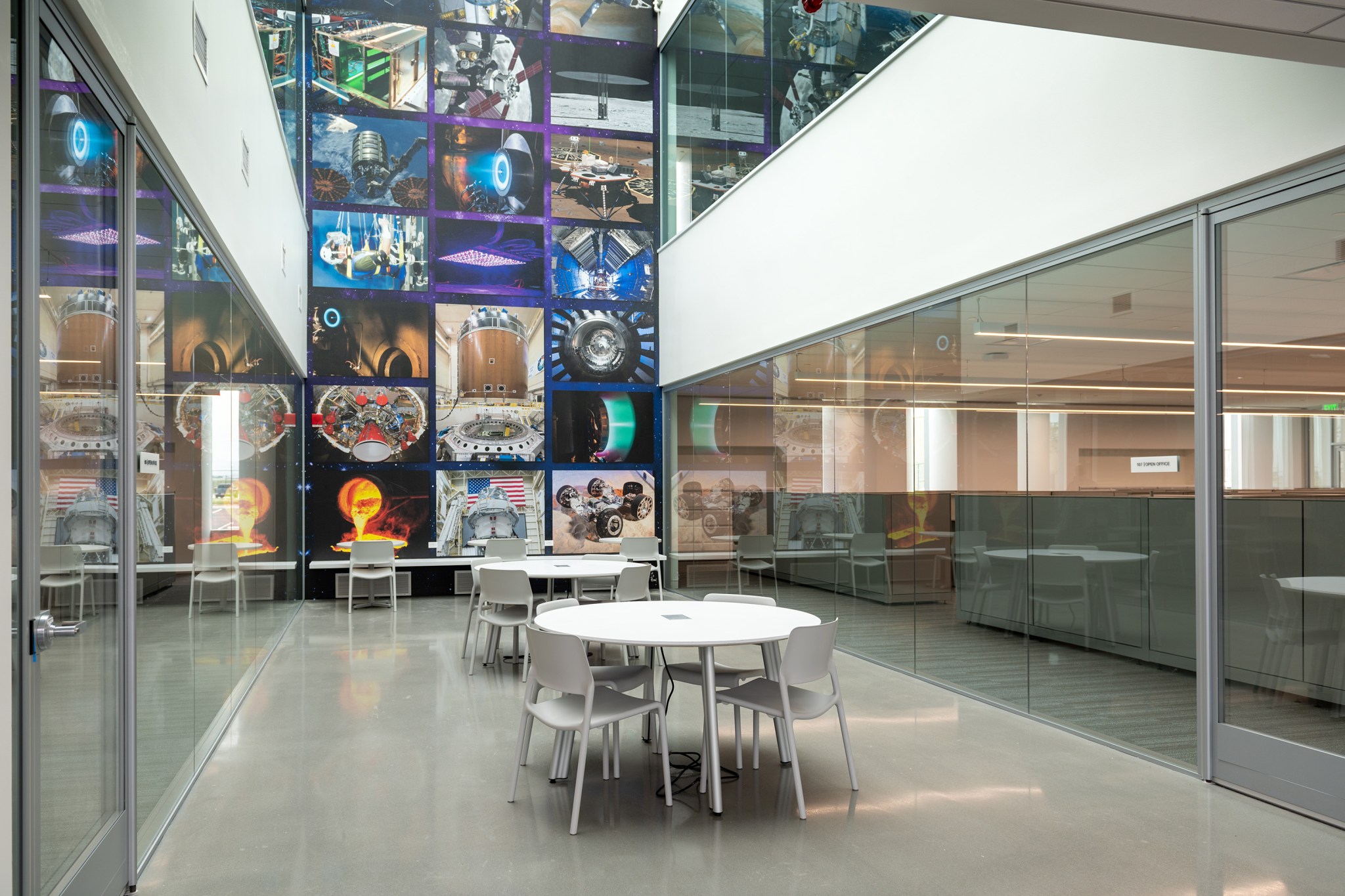 A large feature wall in the background with colorful banners covering the wall, and tables and chairs in the foreground.