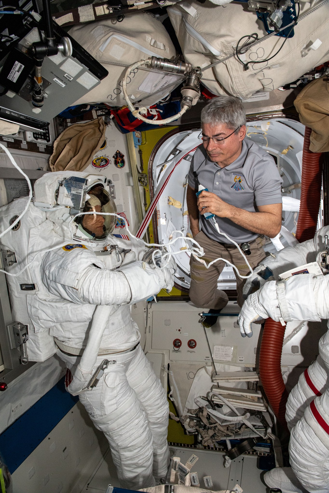 NASA astronaut Kayla Barron in her Extravehicular Mobility Unit during Expedition 66. NASA astronaut Mark Vande Hei is visible in the background.