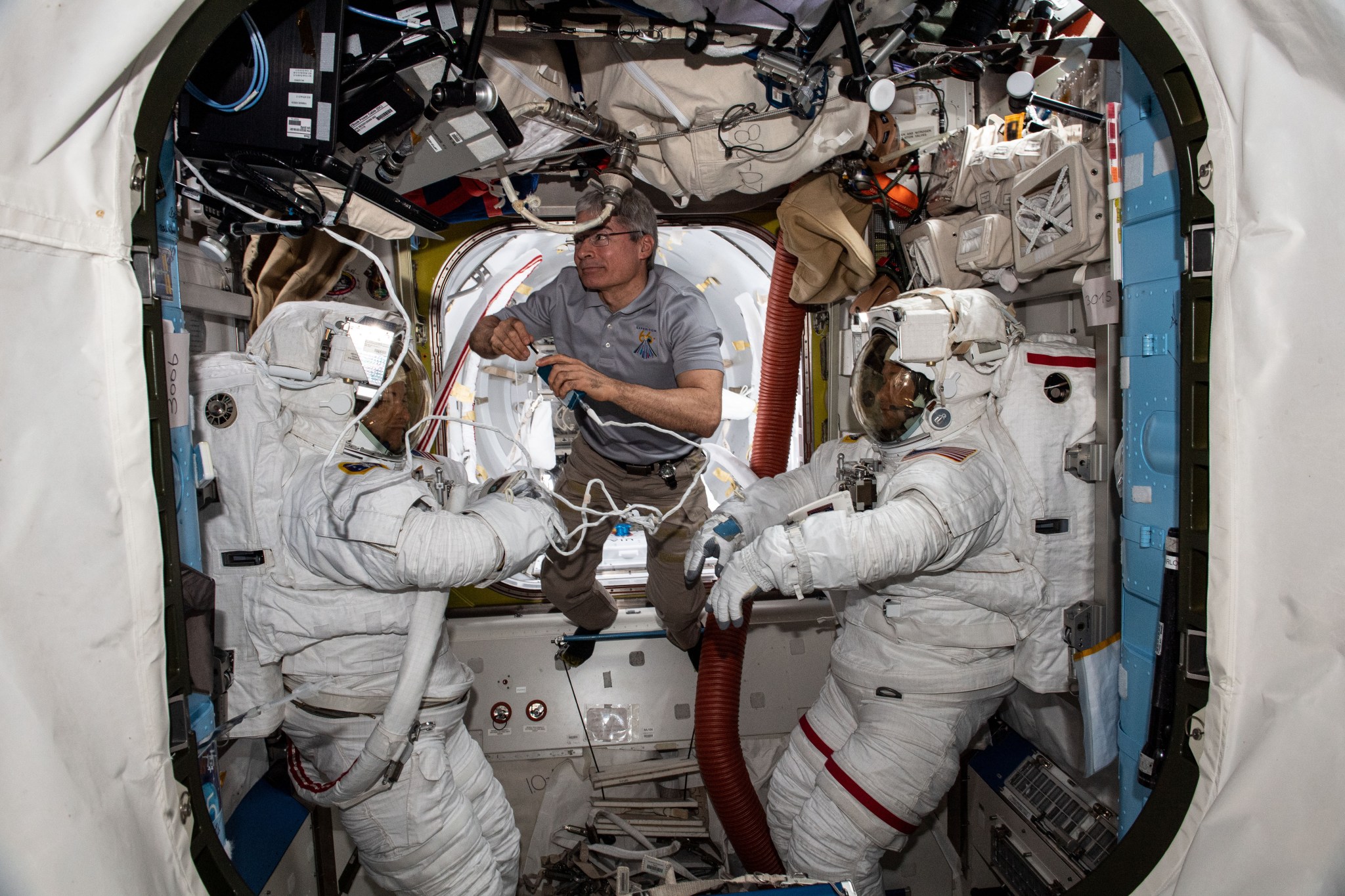 NASA astronaut Mark Vande Hei assists NASA astronauts, from left, Kayla Barron and Thomas Marshburn in the U.S. Quest airlock Nov. 18, 2021. 