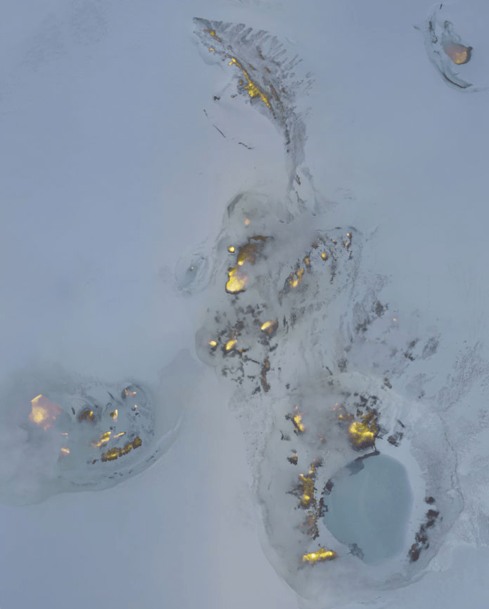 Aerial photograph of the summit of Makushin Volcano in Alaska, overlaid with thermal image data in yellow. 